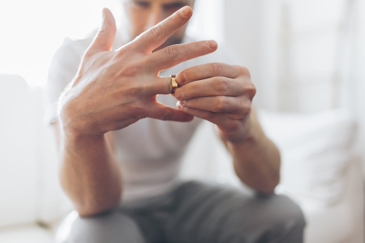 Man taking wedding ring off divorce