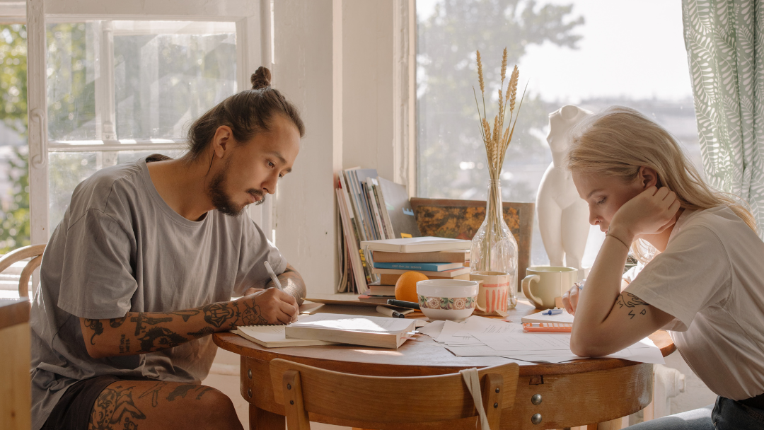 Couple sat at table signing documents