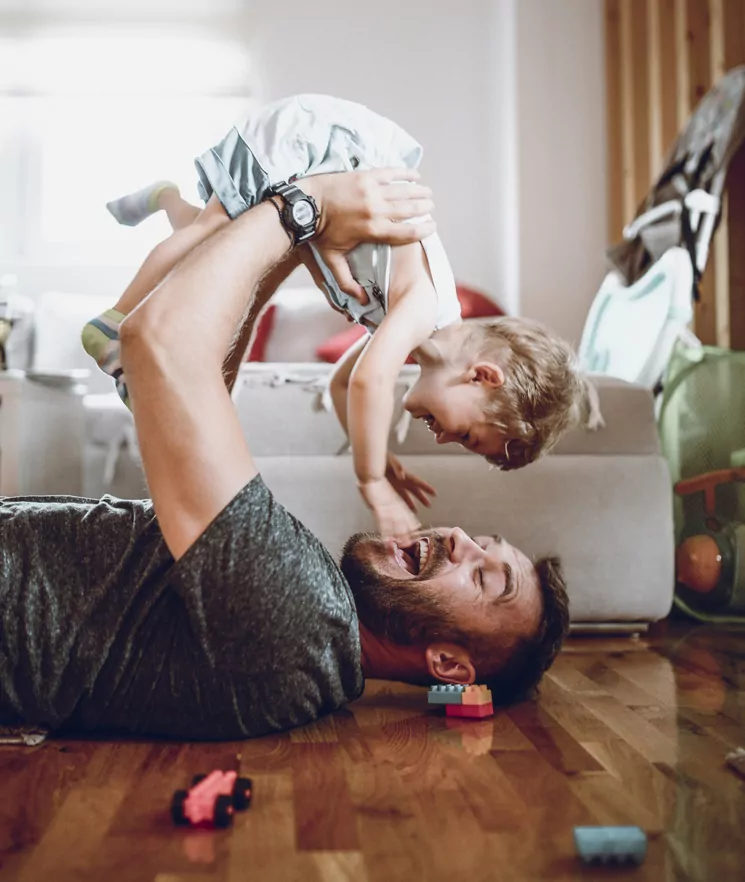 Father Having Fun With Baby Son In Living Room. Illustration for child law solicitors page.