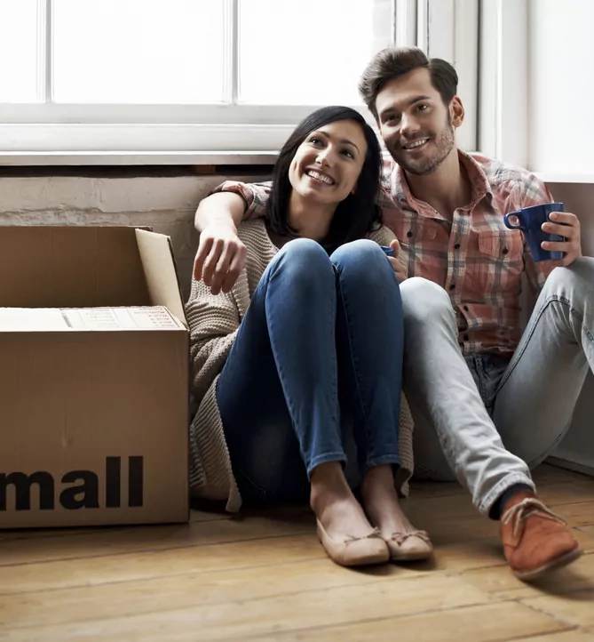 couple sat next to moving boxes - cohabitation solicitors